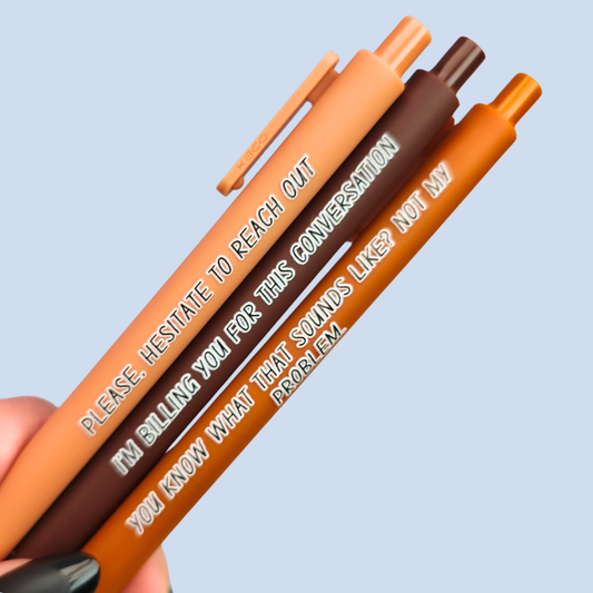 Three pens with sayings on them. "Please, hesitate to reach out"(caramel pen), "I'm billing you for this conversation" (brown pen), "You know what that sounds like? Not my problem" ( sienna pen). 