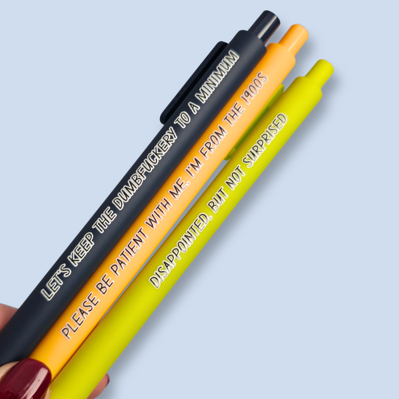 Three pens with humorous text on a light blue background