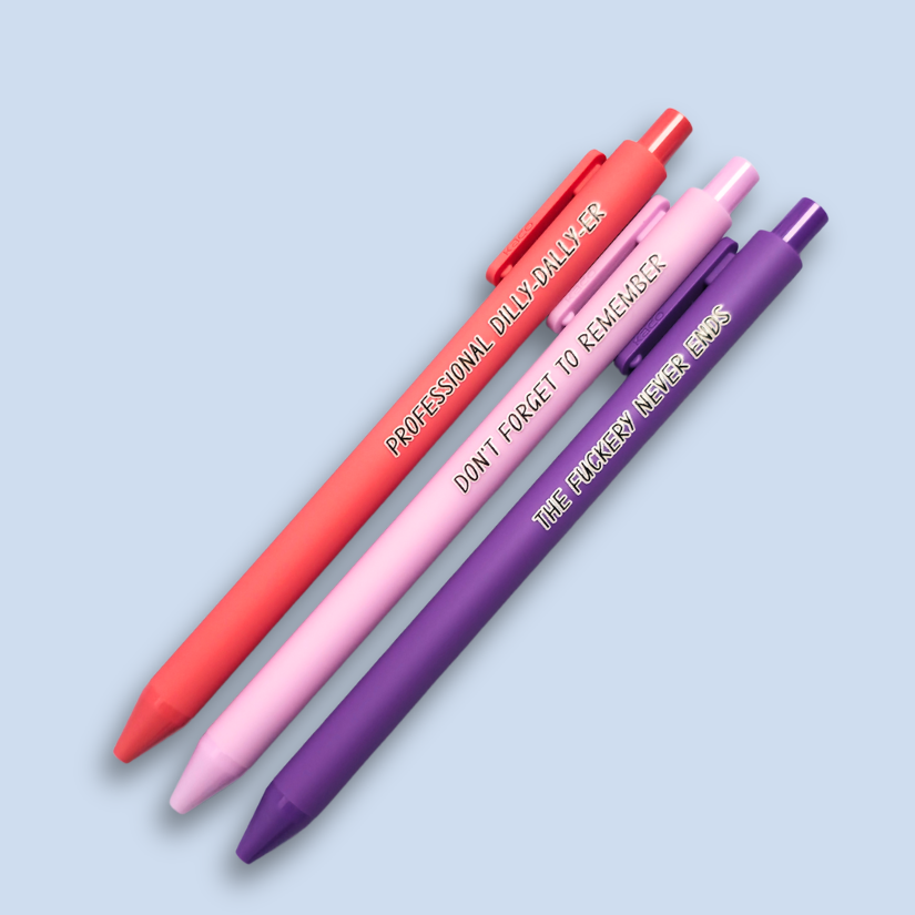 Three pens with humorous text on a light blue background. Text reads, "Professional Dilly-Dally-Er" on a Salmon pink pen, "Don't forget to remember" on a lilac pen and "The fuckery never ends" on a purple pen