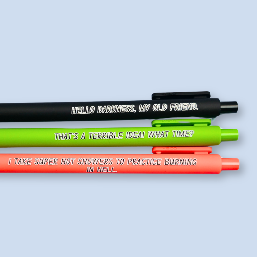 Three pens with quotes. "Hello darkness, my old friend." on a black pen, ' That's a terrible idea. What time?" on a lime green pen, and "I take super hot showers to practice burning in hell" on a orange pen.