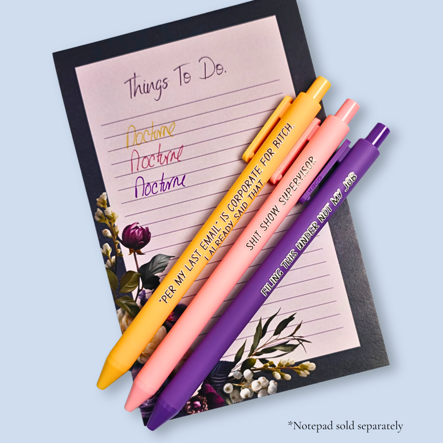 Three pens with sayings on them. "Per My Last Email" is Corporate for bitch, I already said that."(bright yellow pen), "Shit show supervisor" (pastel Pink pen), "Filing this under not my job" ( purple pen). Ink matches the color of the pen