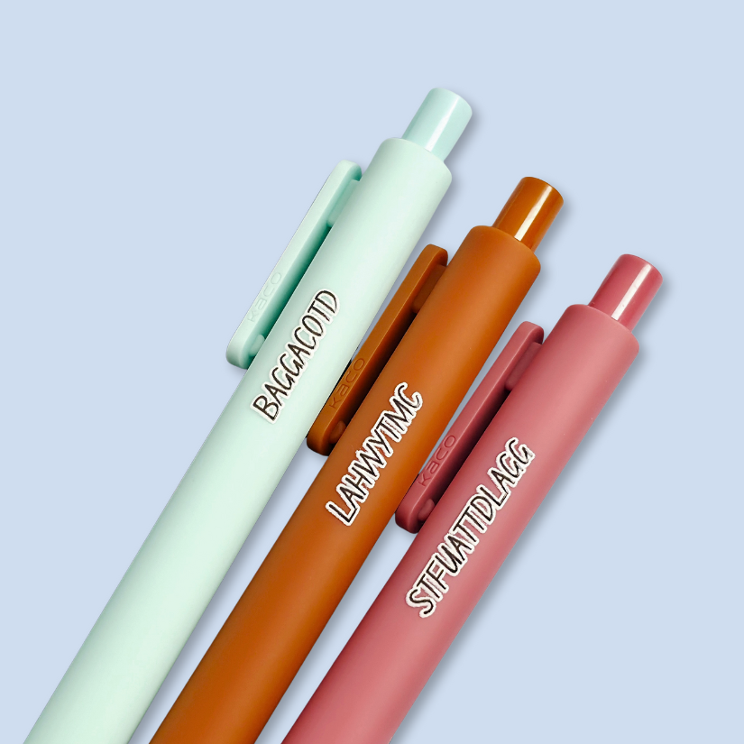 Three pens with sayings on them. "LAHWYTMC"(sienna pen), "BAGGACOTD" (mint pen), "STFUATTDLAGG" ( dust rose pen).