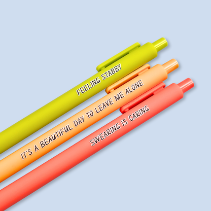 Three pens with sayings on them. "Feeling Stabby."(Lime pen), "It's a beautiful day to leave me alone" (Sunflower yellow pen), "Swearing is caring" ( neon orange pen).