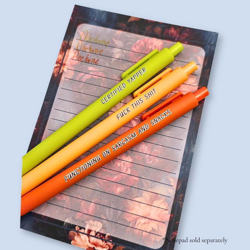 Three pens with sayings on them. "certified yapper" (lime green pen), "Functioning on sarcasm and snacks" (neon orange pen), "fuck this shit" (sunflower yellow pen).