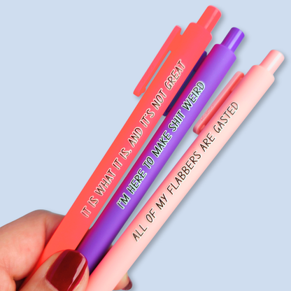 Three pens with sayings on them. "All of my flabbers are gasted" (pastel pink pen), "I'm here to make shit weird" (purple pen), "It Is what it is, and it's not great" ( neon pink pen).