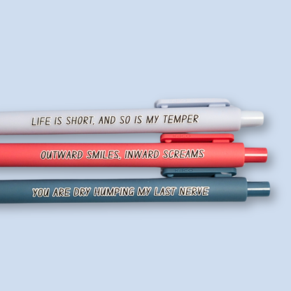 Three pens with humorous text on a light blue background. Text reads, "Life is short, and so is my temper" on a pastel blue pen, "You are dry humping my last nerve" on a blue grey pen and "Outward smiles, inward screams" on a salmon pink pen