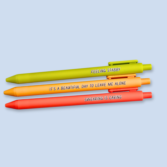 Three pens with sayings on them. "Feeling Stabby."(Lime pen), "It's a beautiful day to leave me alone" (Sunflower yellow pen), "Swearing is caring" ( neon orange pen).