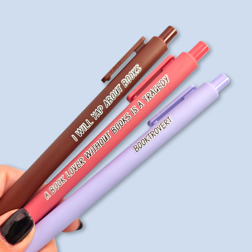 Three pens with book-themed text on a light blue background