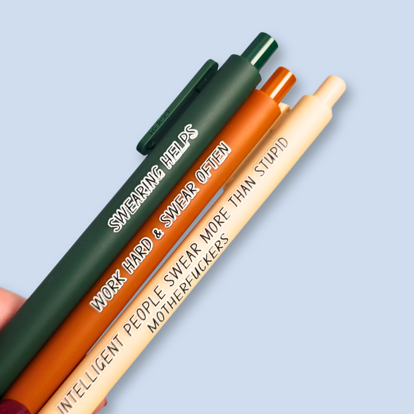 Three pens with sayings on them. "Swearing Helps"(forest green  pen), "Work Hard & Swear often" (sienna pen), "Intelligent people swear more than stupid motherfuckers" ( linen pen). 