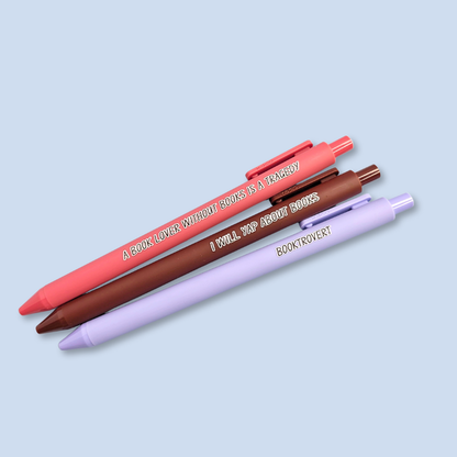 Three pens with book-themed text on a light blue background