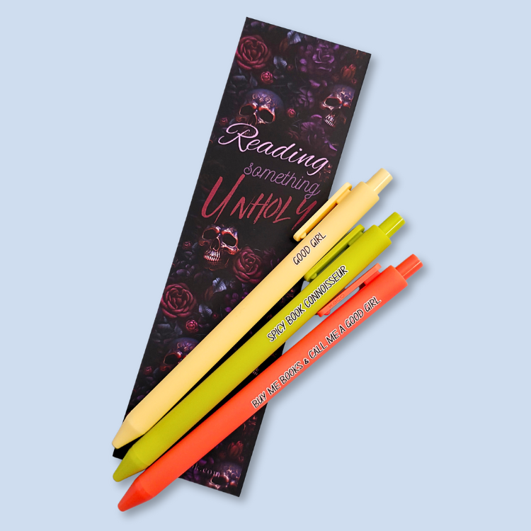 Three pens with quotes. "Good Girl" on a yellow pen, "Spicy Book Connoisseur" on a neon green pen, and "Buy me books and call me a good girl" on a neon orange pen.
