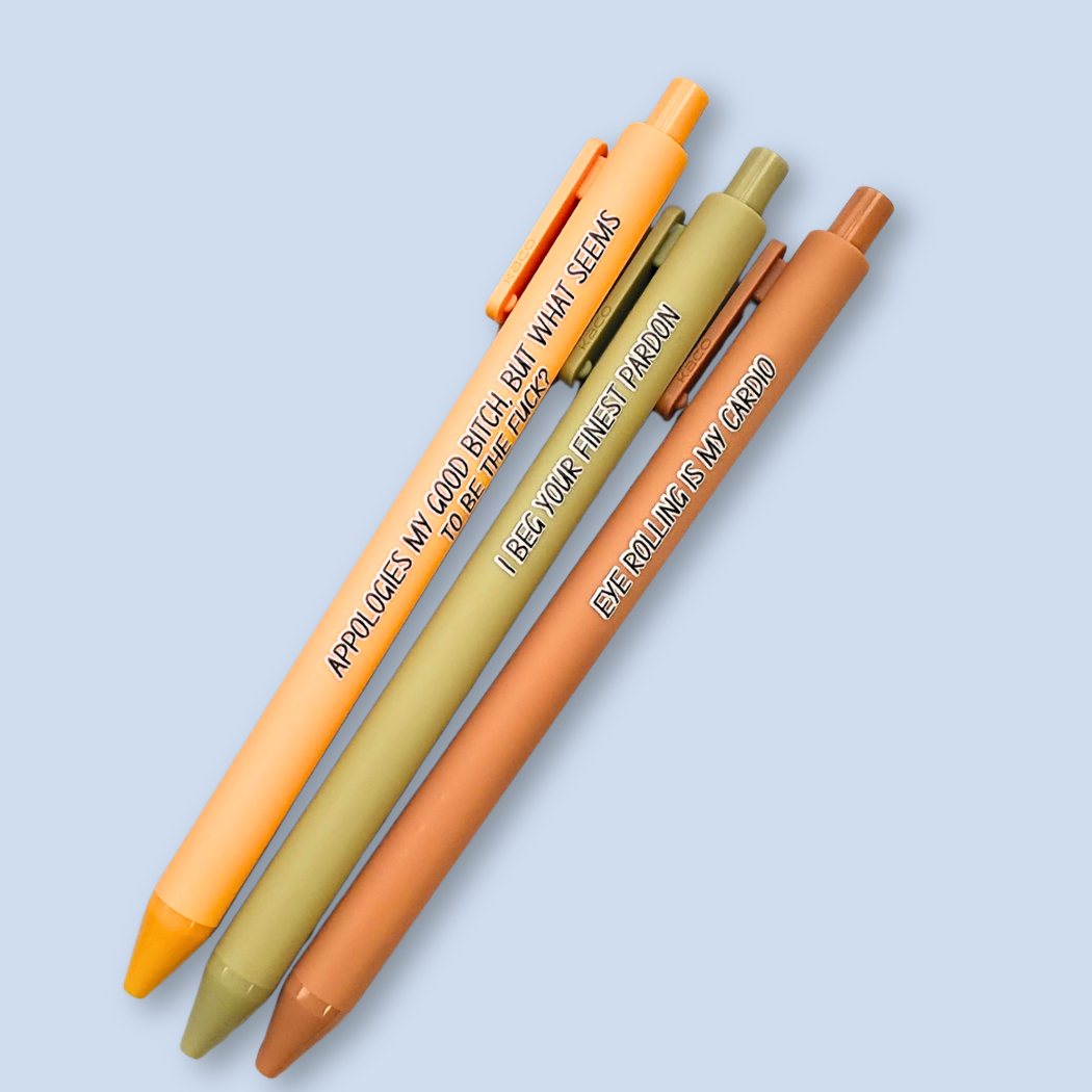 Three retractable gel pens in orange, olive green, and terracotta brown, arranged diagonally on a light blue background. Each pen features black printed text on the barrel.