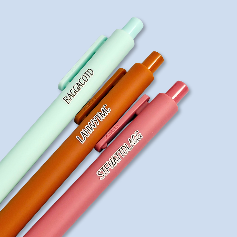 Three pens with sayings on them. "LAHWYTMC"(sienna pen), "BAGGACOTD" (mint pen), "STFUATTDLAGG" ( dust rose pen).