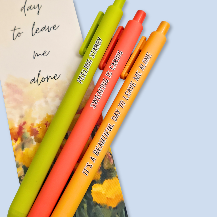 Three pens with sayings on them. "Feeling Stabby."(Lime pen), "It's a beautiful day to leave me alone" (Sunflower yellow pen), "Swearing is caring" ( neon orange pen).