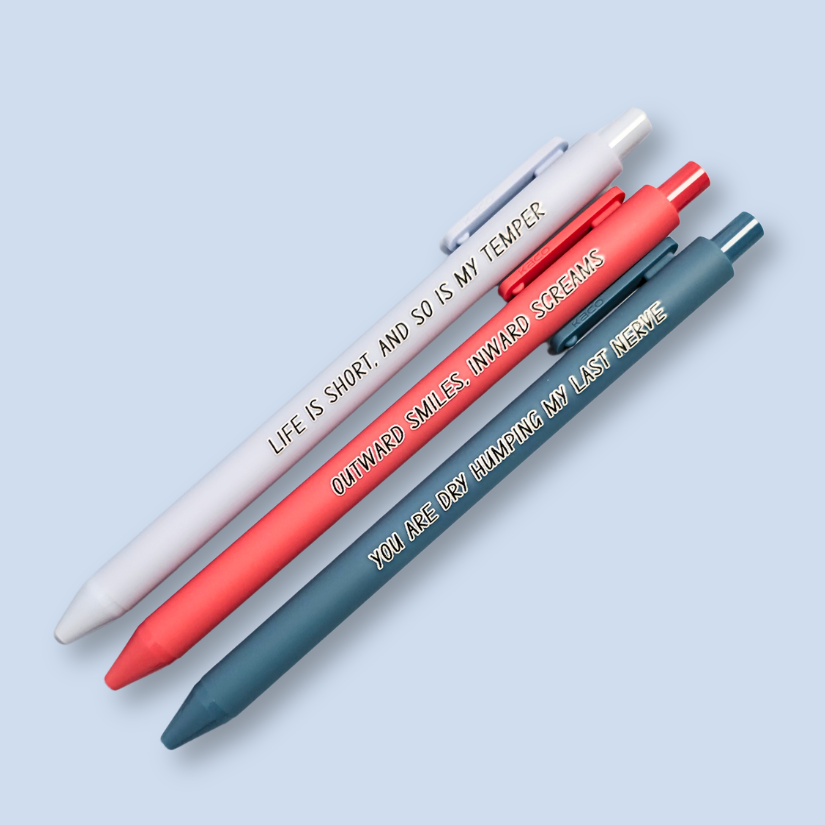 Three pens with humorous text on a light blue background. Text reads, "Life is short, and so is my temper" on a pastel blue pen, "You are dry humping my last nerve" on a blue grey pen and "Outward smiles, inward screams" on a salmon pink pen