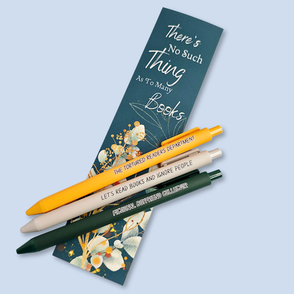 Three pens with sayings on them. "Fictional Boyfriend Collector"(forest green pen), "The Tortured Readers Department" (bright yellow pen), "Let's read books and ignore people" ( light grey pen).