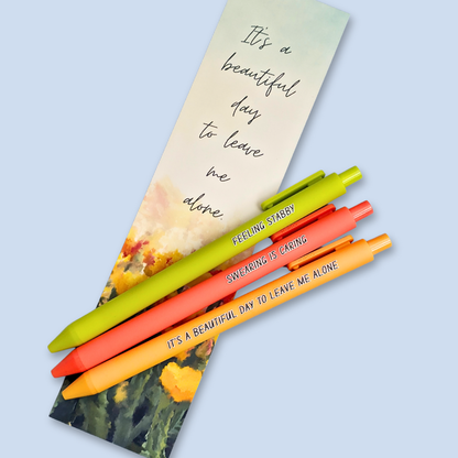 Three pens with sayings on them. "Feeling Stabby."(Lime pen), "It's a beautiful day to leave me alone" (Sunflower yellow pen), "Swearing is caring" ( neon orange pen).