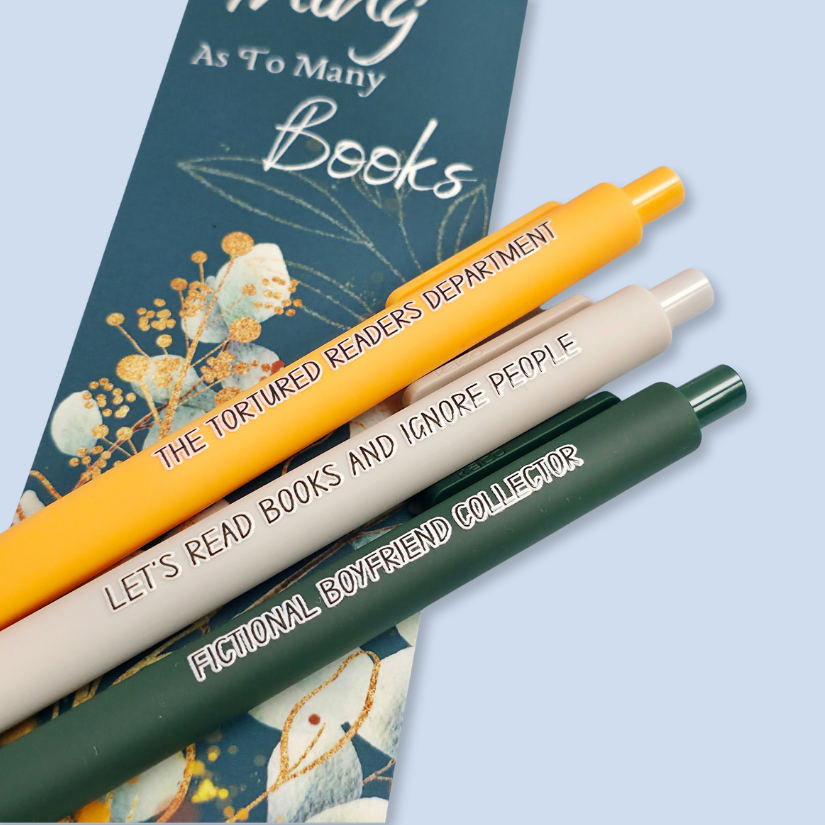 Three pens with sayings on them. "Fictional Boyfriend Collector"(forest green pen), "The Tortured Readers Department" (bright yellow pen), "Let's read books and ignore people" ( light grey pen).