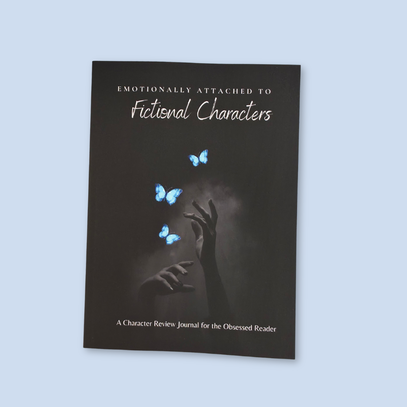 A dark journal titled 'Emotionally Attached to Fictional Characters' with a cover showing blue butterflies and raised hands, photographed against a light blue background.
