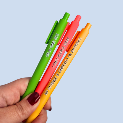 Three colorful pens held by a hand with a light blue background. Pens read: CALM YOUR TITS (this pen is lime green), I CAN'T PEOPLE TODAY (this pen is coral color), and MY PATIENCE IS CURRENTLY ON BACKORDER (this pen is yellow)